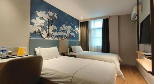 a hotel room with two beds and a painting on the wall at Magnotel Shanghai Henglong Plaza in Shanghai