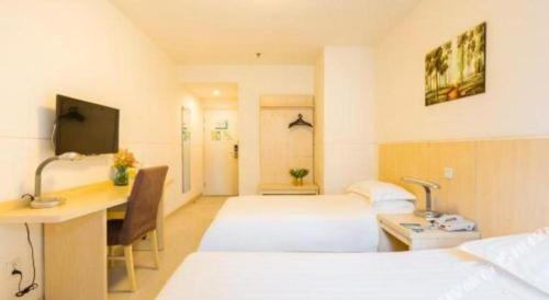 a hotel room with two beds and a desk with a computer at Magnotel Shanghai Henglong Plaza in Shanghai