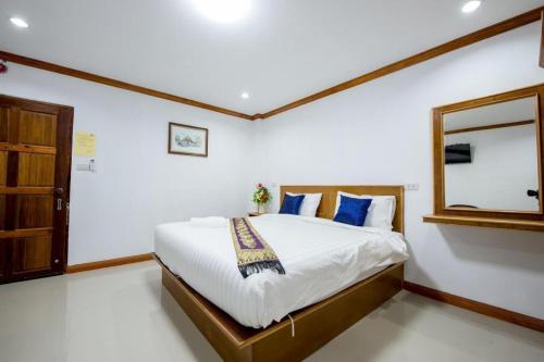 a bedroom with a bed with blue pillows and a mirror at Thatphanom View Hotel Nakhon in Nakhon Phanom