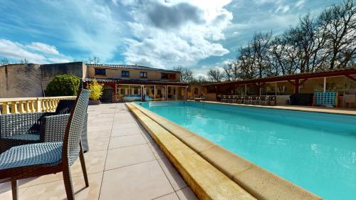 une piscine avec des chaises à côté d'un bâtiment dans l'établissement Le Clos Des Dryades g, à Vers