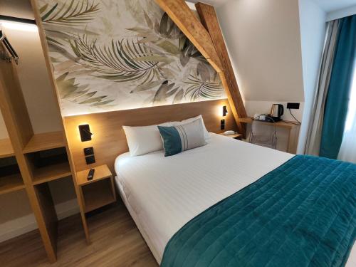 a bedroom with a bed and a painting on the wall at 55 Hôtel Montparnasse in Paris