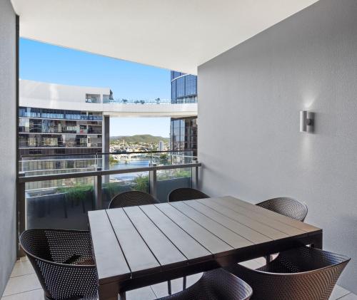 a dining room with a table and chairs and a large window at Queen's Wharf Residences Official in Brisbane