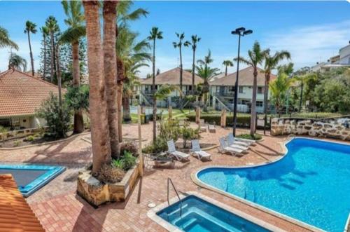 a swimming pool with palm trees and a resort at Ocean Breeze Loft Villa With Pool, Tennis Court & Playground! in Mandurah