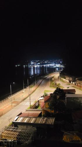 a city street at night with lights in the distance at Playa Tomé Chile in Tomé
