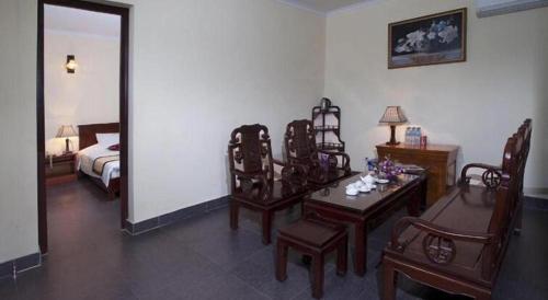 a room with a bedroom with a table and chairs at Hai Au Hotel in Hai Phong