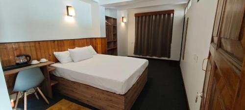 a hotel room with a bed and a desk and a bed sidx sidx sidx sidx at Mudita Stays in Darjeeling