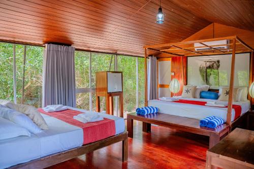 ein Schlafzimmer mit zwei Betten und einer Holzdecke in der Unterkunft Lowin Yala in Yala