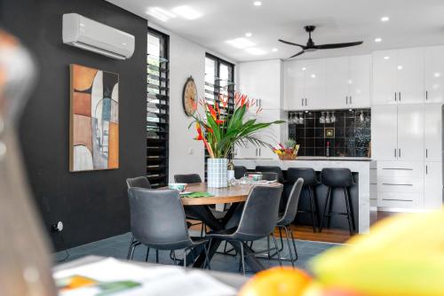 a dining room and kitchen with a table and chairs at Belle Escapes Villa Riviera in Palm Cove