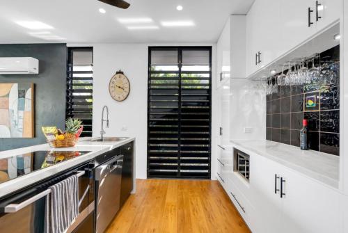 a kitchen with white walls and a wooden floor at Belle Escapes Villa Riviera in Palm Cove
