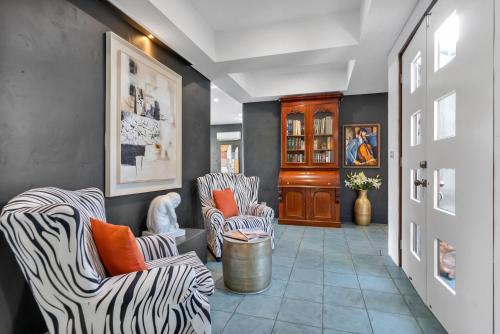 a hallway with zebra chairs and a hallway with a hallway at Belle Escapes Villa Riviera in Palm Cove
