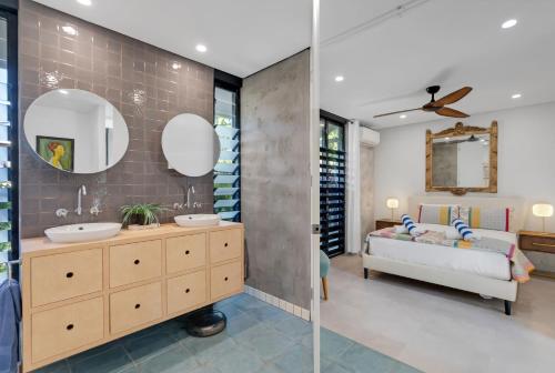 a bathroom with a sink and a bed in a room at Belle Escapes Villa Riviera in Palm Cove