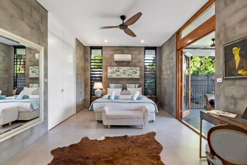 a bedroom with two beds and a ceiling fan at Belle Escapes Villa Riviera in Palm Cove