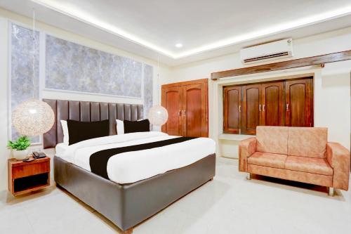 una camera da letto con un letto grande e una sedia di Super Collection O Tagore Town Prayagraj Formerly Heritage Tagore a Prayagraj
