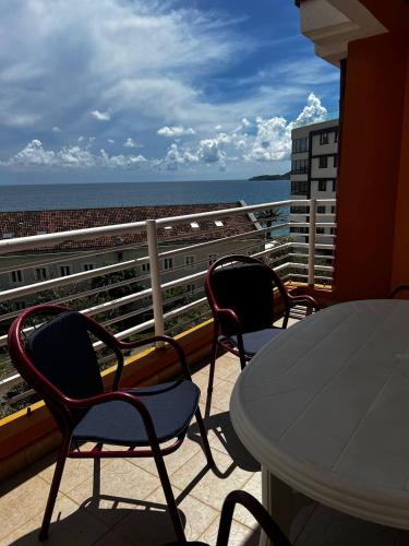 a balcony with a table and chairs and the ocean at Better place in Becici
