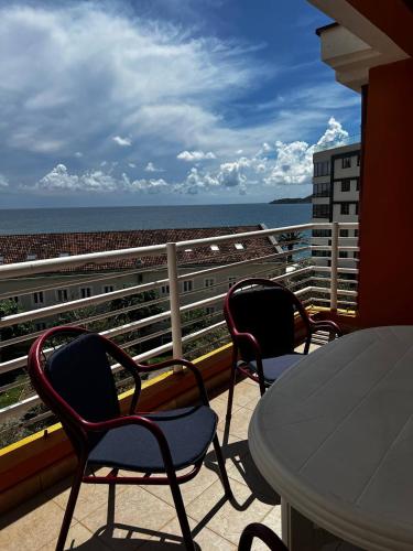 a balcony with chairs and a table and the ocean at Better place in Becici