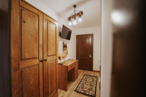 a bathroom with a wooden closet and a door at Hanul lui Mujdei in Vatra Dornei