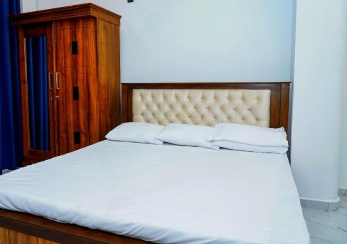 a bed with white sheets and pillows in a bedroom at Akshana Residency in Mount Lavinia
