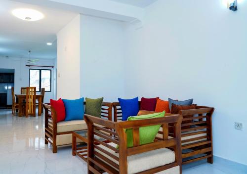 a room with a couch with colorful pillows on it at Akshana Residency in Mount Lavinia