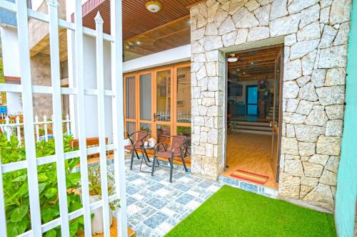 a house with a stone wall and a patio at An's House SaPa - Nguyên Căn 5 Phòng Ngủ View Núi in Sa Pa