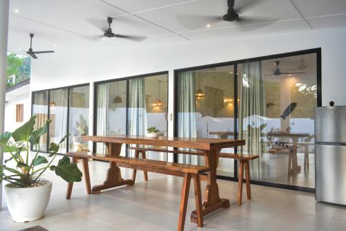 a wooden table and bench in a room with windows at White House Villa El Nido in El Nido