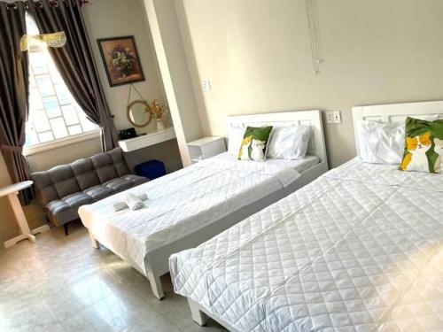 a hotel room with two beds and a couch at Homestay Hoa Hồng in Liên Trì (4)