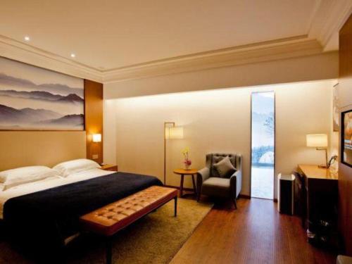 Un dormitorio con una cama y una silla dentro. en Yitel Collection Hangzhou West Lake Jiefang Road, en Hangzhou