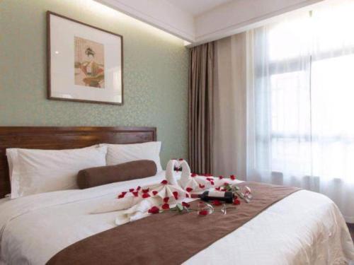 a hotel room with a bed with flowers on it at James Joyce Coffetel Xian Dayanta Metro Station Branch in Xi'an