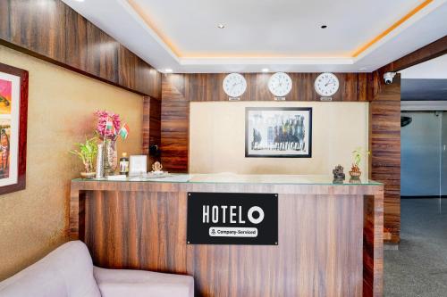 a hotel reception desk with clocks on the wall at Super Hotel O Koramangala Near Sony Signal in Bengaluru