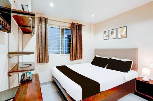 a bedroom with a large bed and a window at Super Hotel O Koramangala Near Sony Signal in Bengaluru
