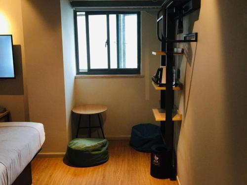 a small room with a bed and a window at YUNIK-Shanghai Zhongshan Park Yan'an Xi Road in Shanghai