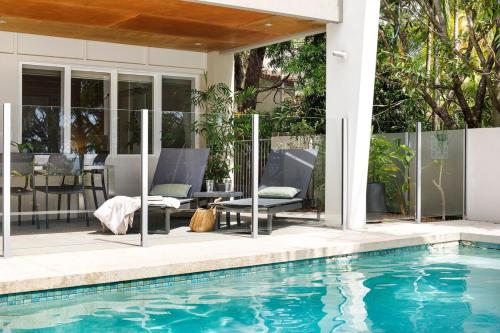 een huis met een zwembad en een patio bij Prime Location, Views & Sunsets, Walk to Hastings in Noosa Heads