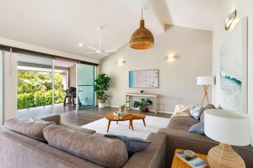 een woonkamer met een bank en een tafel bij Prime Location, Views & Sunsets, Walk to Hastings in Noosa Heads