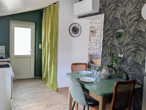 une cuisine et une salle à manger avec une table et des chaises vertes dans l'établissement Maison garde barrière, à Arcis-sur-Aube