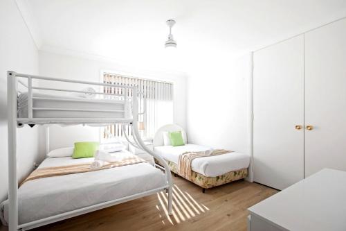 two bunk beds in a room with white walls at Budgewoi Waterfront Haven in Budgewoi