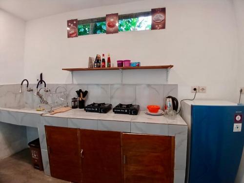 a kitchen with a stove and a counter top at Roby Homestay in Kuta Lombok