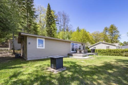 a small house in a yard with a table in the grass at Beautiful Torch Lake House with Beach Access home in Rapid City