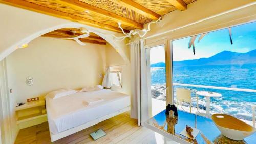 Utopia boutique villa on-in the water between 2 seas ideal 5 people في Kástron: غرفة نوم مع سرير وإطلالة على المحيط