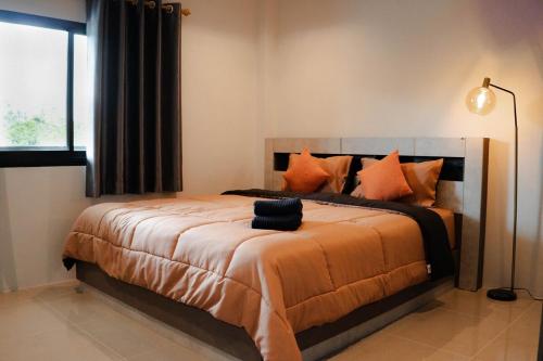 a bedroom with a large bed with orange pillows at Private Sanctuary Yanui beach in Nai Harn Beach