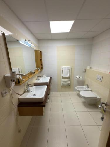 a bathroom with two sinks and two toilets at Penzión Siroň in Detva