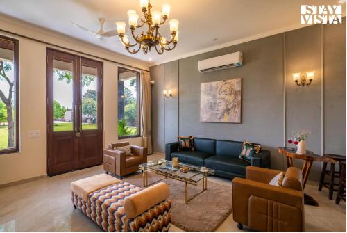 a living room with a couch and a table at StayVista at The Mira House with Pool, WiFi in Sohna