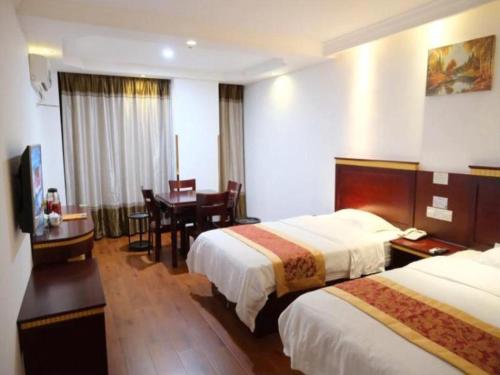 a hotel room with two beds and a desk at GreenTree Inn Shanghai Minhang Development Zone Subway Station Business Hotel in Shanghai