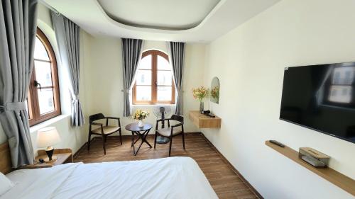 a bedroom with a bed and a tv on a wall at Coconut Garden H in Phu Quoc