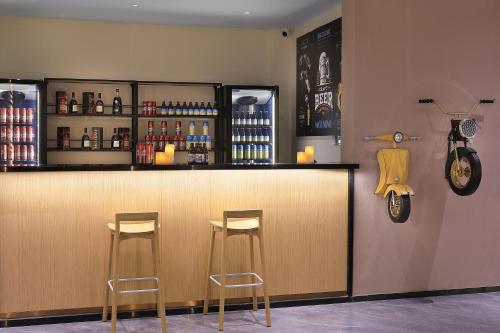 a bar with two stools and a motorcycle on the wall at Yangshuo CheerMay Hotel in Yangshuo
