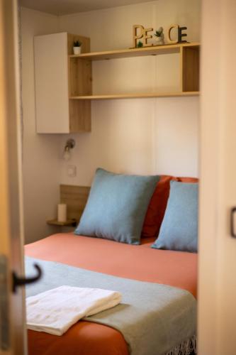 - une chambre avec 2 lits dotés d'oreillers bleus dans l'établissement Mobile-home 4 à 6personnes au camping LES VIVIERS, à Lège-Cap-Ferret