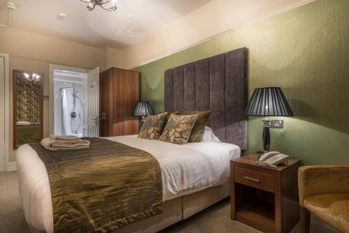 a bedroom with a bed and a phone on a table at The Royal Oak Hotel, Welshpool - The Coaching Inn Group in Welshpool