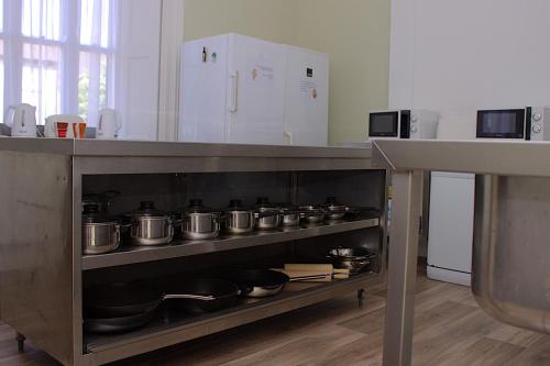 a bunch of pots and pans on a shelf in a kitchen at The Monkey Puzzle in Bunclody