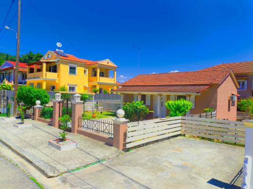 a yellow house with a fence in front of it at Bella Casa in Petrití