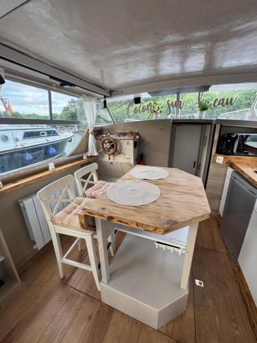 a table and chairs in the middle of a boat at Cocon sur l eau in Montargis