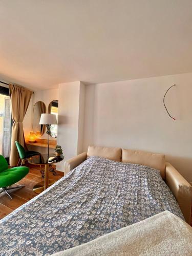 a bedroom with a bed and a green chair at Coup de cœur BB in Cogolin