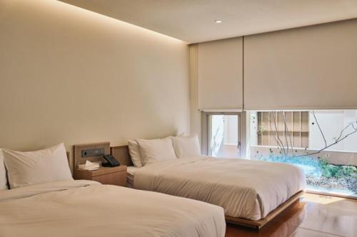 a bedroom with two beds and a window at IJE Gyeongju in Gyeongju